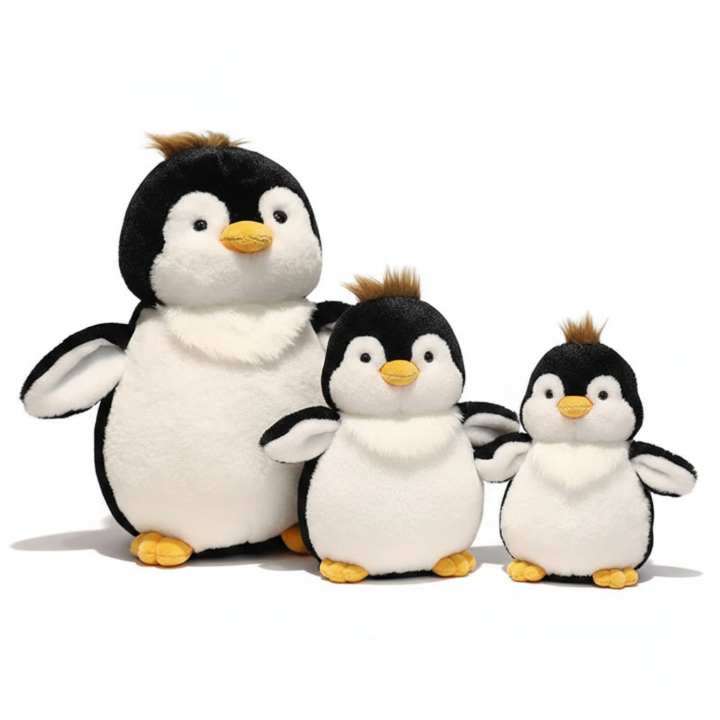 Three plush penguins sitting together on a wooden surface with a blurred background.
