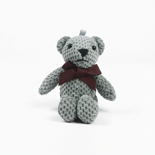 Crocheted teddy bear with a brown ribbon on a white background