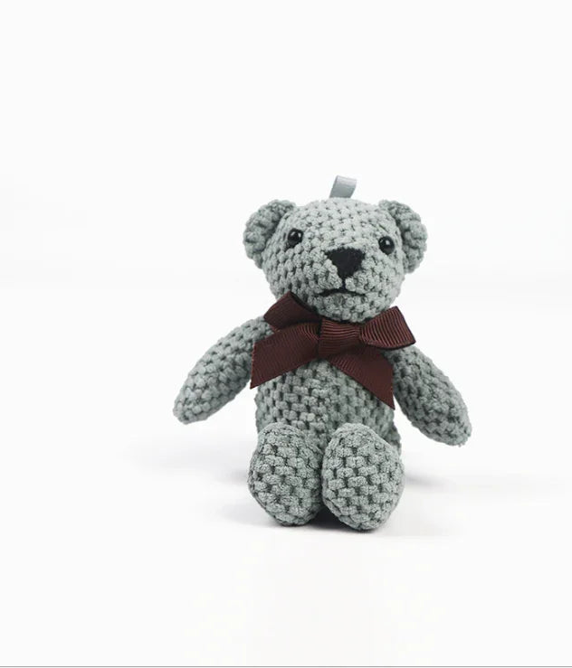 Crocheted teddy bear with a brown ribbon on a white background