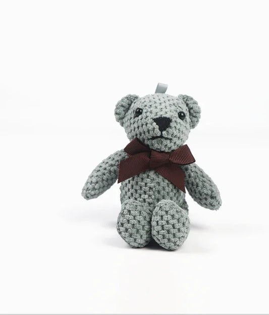 Crocheted teddy bear with a brown ribbon on a white background