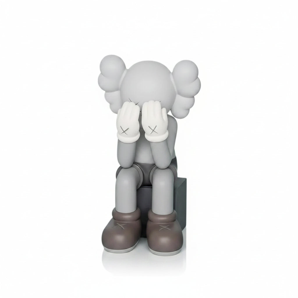 Gray and brown KAWS sculpture with closed eyes on a light blue background