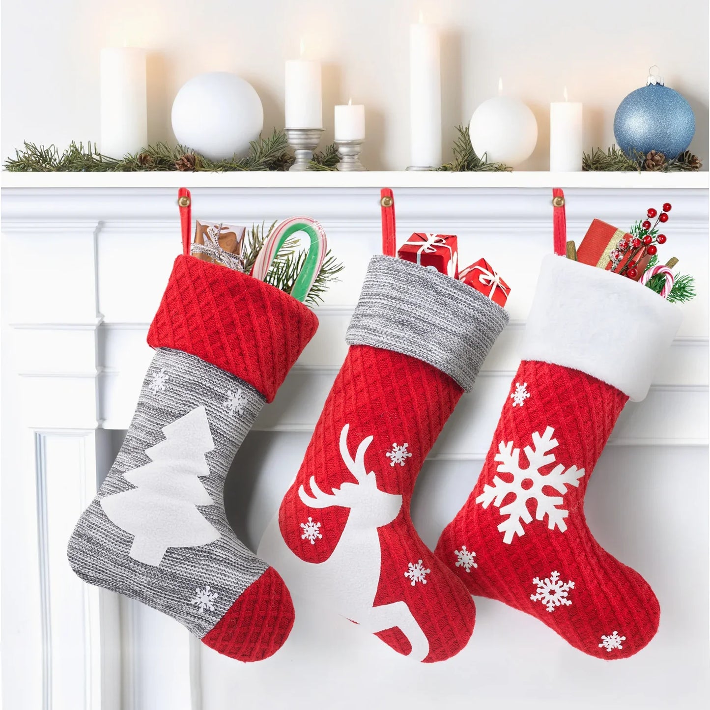Three Christmas stockings with festive designs hanging on a fireplace mantle.