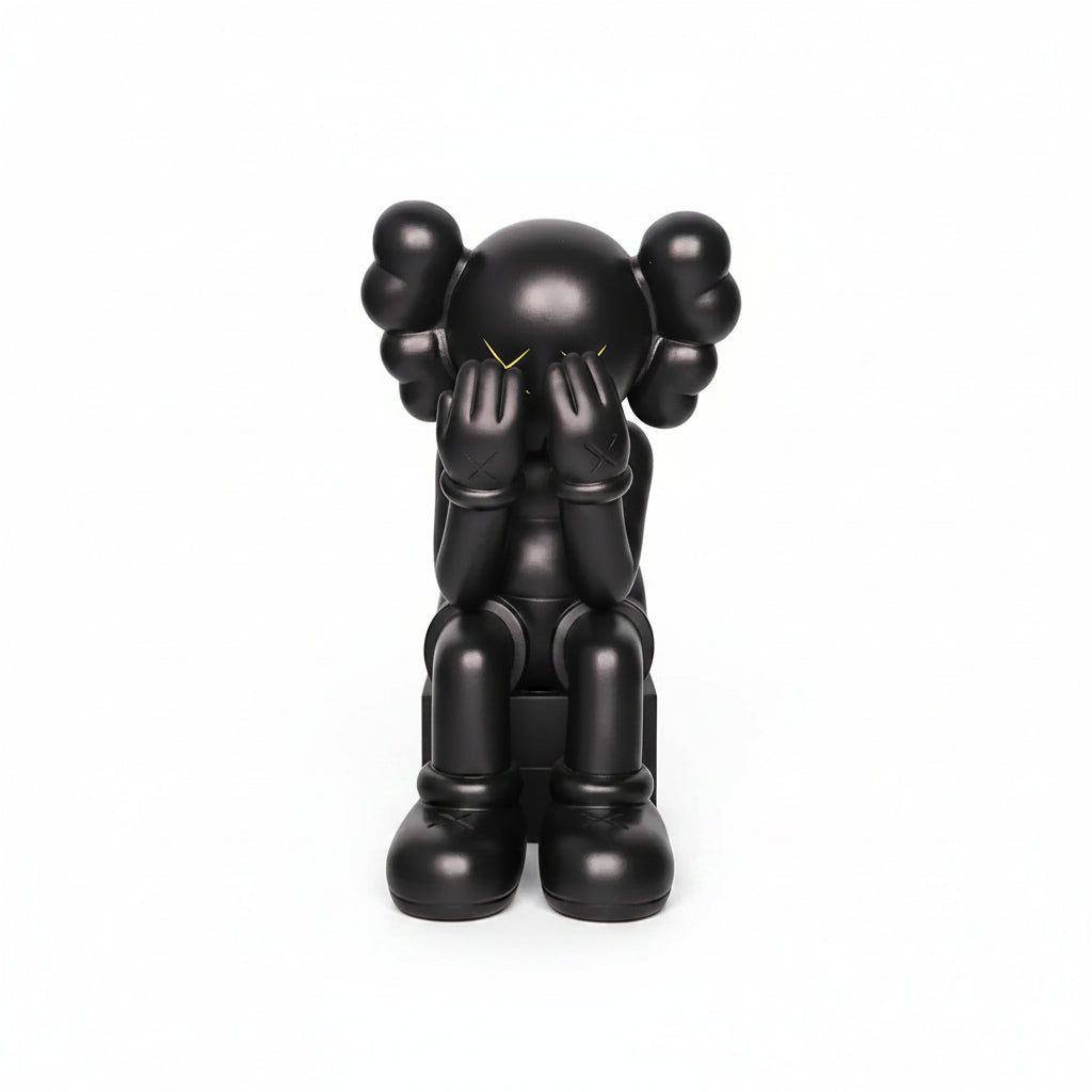 Black sculpture of a figure with a minimalist design on a light gray background