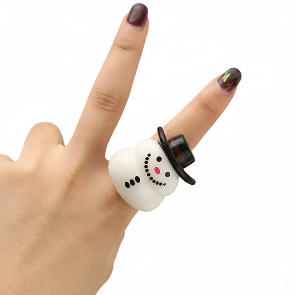 Snowman-shaped air pod case on a finger with a blurred light background